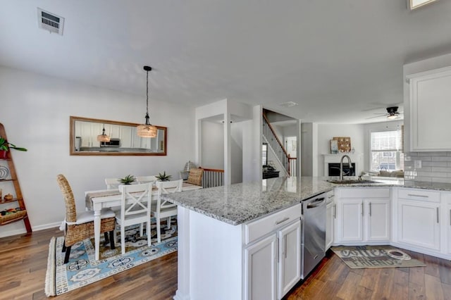 kitchen with white cabinets, dark hardwood / wood-style flooring, and stainless steel dishwasher