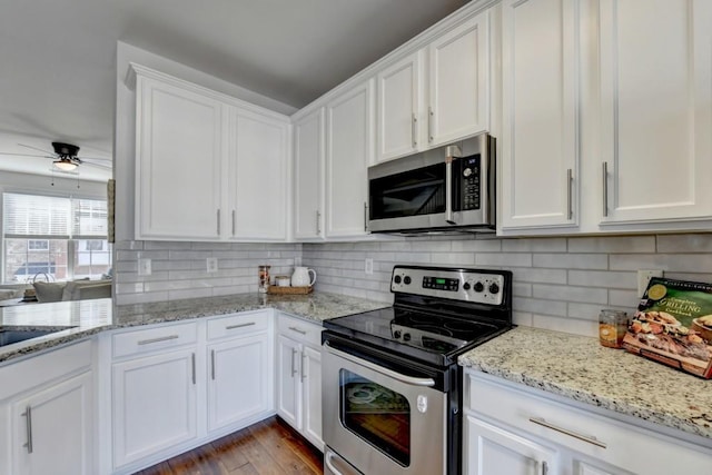 kitchen with white cabinets, stainless steel appliances, ceiling fan, and light hardwood / wood-style floors