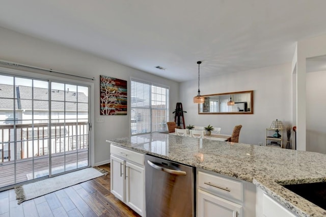 kitchen with stainless steel dishwasher, light stone counters, pendant lighting, white cabinets, and dark hardwood / wood-style floors