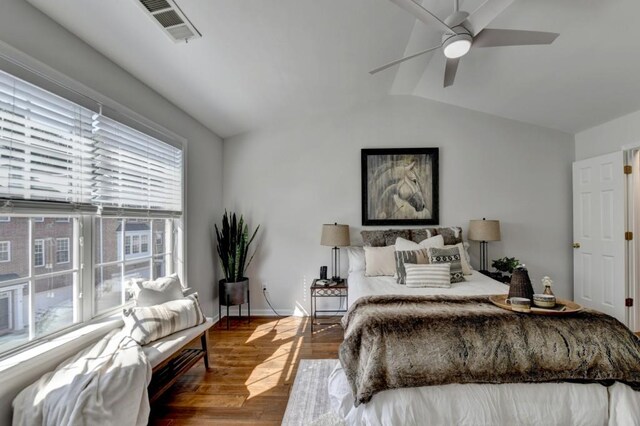 bedroom featuring dark hardwood / wood-style flooring, vaulted ceiling, and ceiling fan