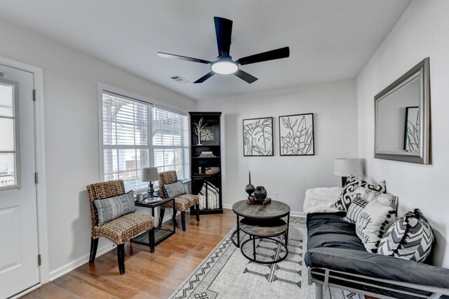 living room featuring hardwood / wood-style floors and ceiling fan