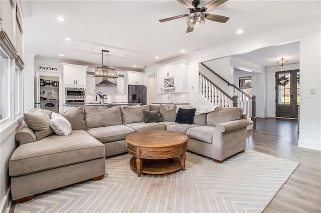 living room with ceiling fan, french doors, sink, and light hardwood / wood-style flooring