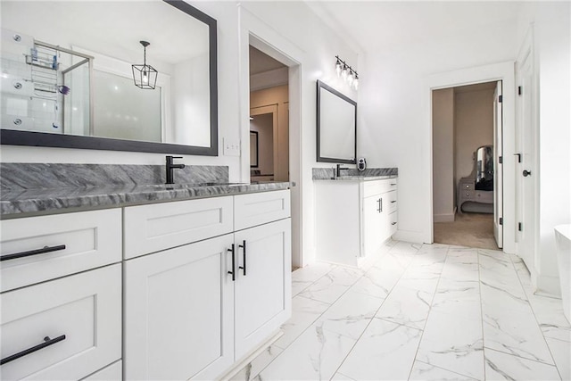 bathroom featuring a shower with shower door and vanity