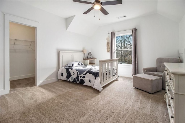 carpeted bedroom featuring a spacious closet, a closet, lofted ceiling, and ceiling fan