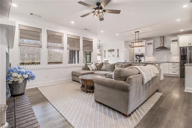 living room with dark wood-type flooring and ceiling fan