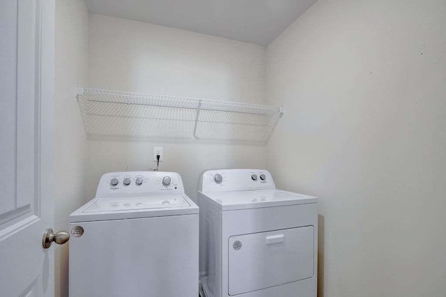 laundry room with laundry area and washing machine and clothes dryer