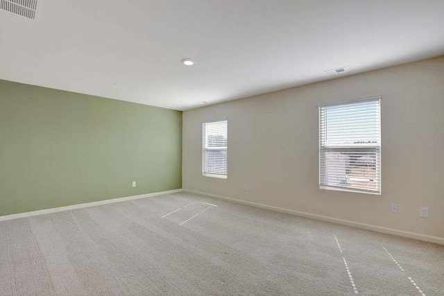 unfurnished room featuring light carpet, visible vents, and baseboards