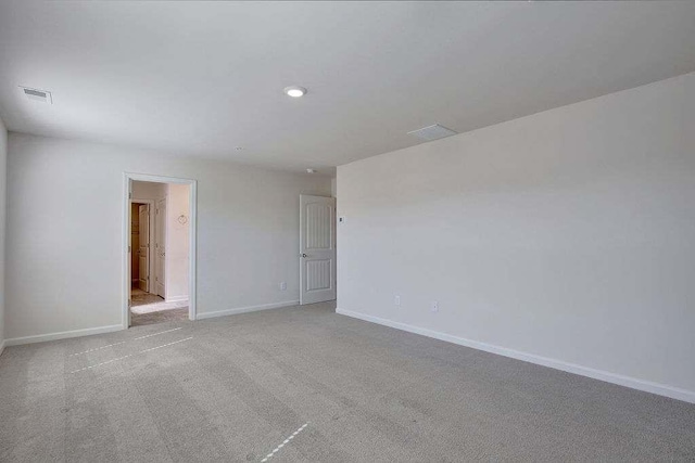 unfurnished room with carpet flooring, visible vents, and baseboards