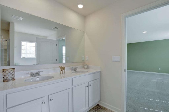 bathroom with baseboards, visible vents, and a sink