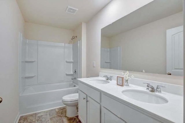 bathroom with toilet, double vanity, visible vents, and a sink