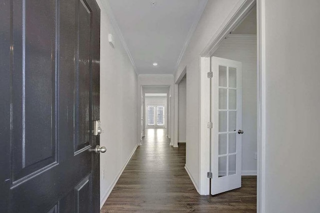 hall with ornamental molding, dark wood-type flooring, and baseboards