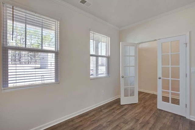 unfurnished room with wood finished floors, visible vents, baseboards, french doors, and crown molding