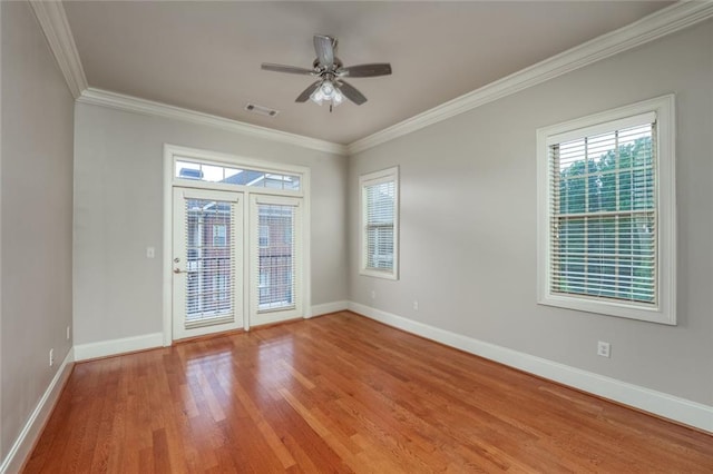 unfurnished room with ornamental molding, baseboards, light wood-type flooring, and healthy amount of natural light