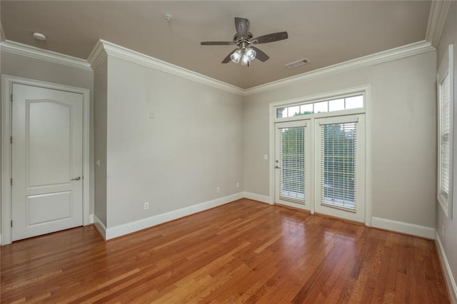 empty room with light wood-type flooring, ornamental molding, baseboards, ceiling fan, and a smoke detector
