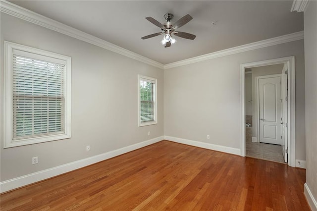 unfurnished room featuring ornamental molding, baseboards, ceiling fan, and light wood-type flooring