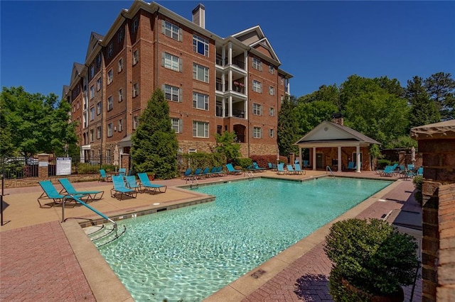 community pool featuring fence and a patio