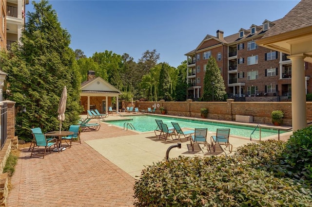 community pool with fence and a patio