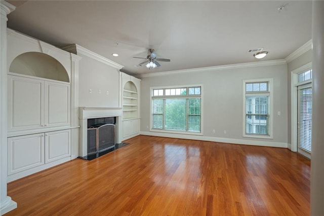 unfurnished living room with ornamental molding, light wood-type flooring, a fireplace, ceiling fan, and baseboards