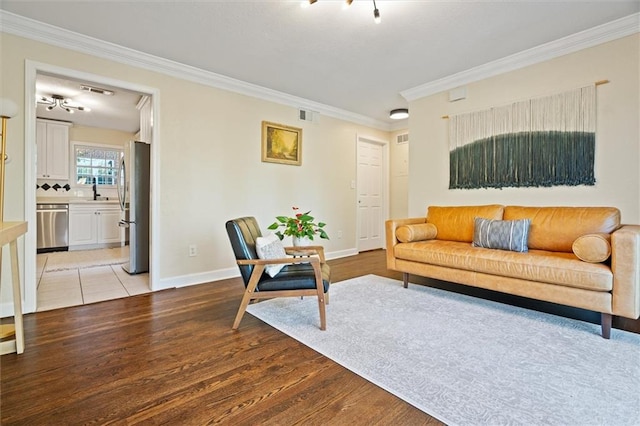 living room with light hardwood / wood-style flooring, ornamental molding, and sink