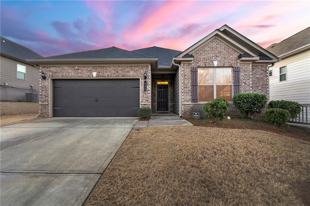 view of front of house featuring a garage, a yard, and central AC unit