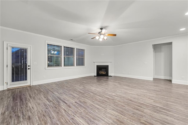 unfurnished living room featuring hardwood / wood-style flooring, crown molding, and ceiling fan