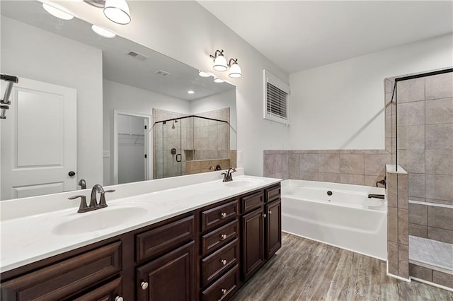 bathroom with vanity, independent shower and bath, and hardwood / wood-style floors