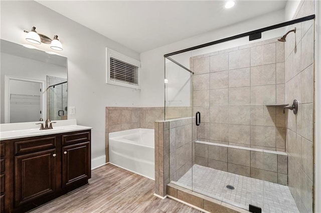 bathroom featuring vanity, separate shower and tub, and hardwood / wood-style floors