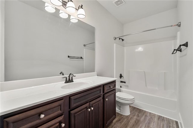 full bathroom featuring vanity, wood-type flooring, toilet, and washtub / shower combination