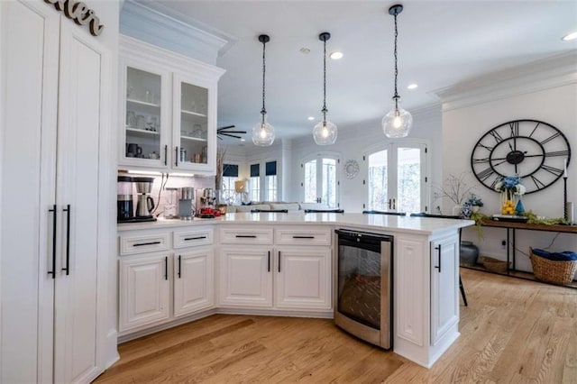2938 Old Dalton Rd, Rome, GA 30165 - kitchen featuring beverage cooler, light countertops, ornamental molding, light wood-type flooring, and white cabinetry