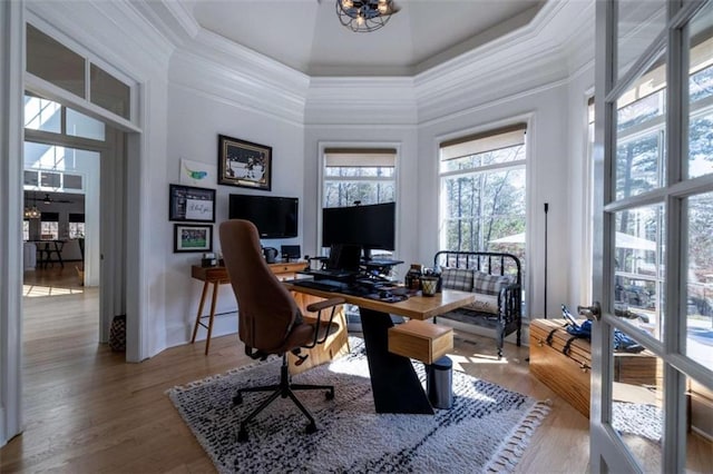 office with crown molding, a towering ceiling, wood-type flooring, and a chandelier