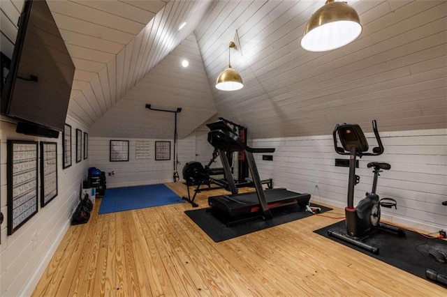 workout area featuring light hardwood / wood-style flooring and vaulted ceiling