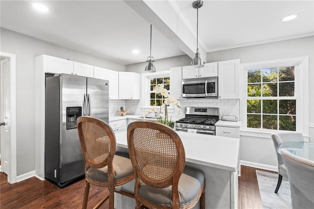 kitchen featuring light countertops, backsplash, dark wood-style flooring, and appliances with stainless steel finishes