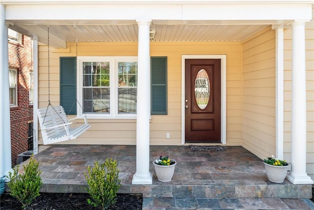 view of exterior entry featuring covered porch