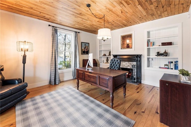 office space featuring light wood-type flooring, a brick fireplace, wood ceiling, and built in features