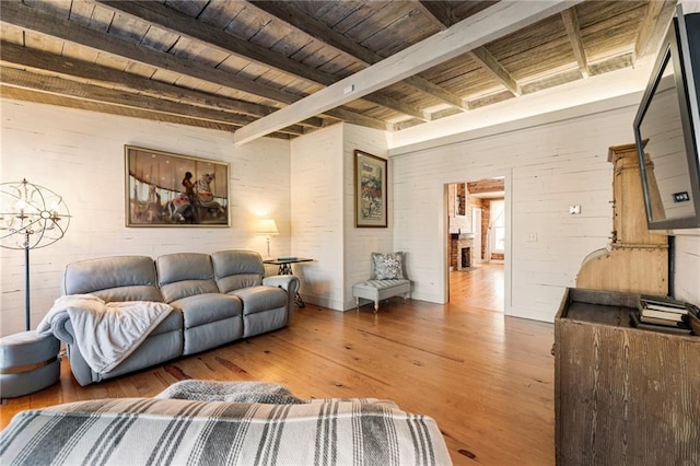 living area featuring wood ceiling, beam ceiling, and wood finished floors