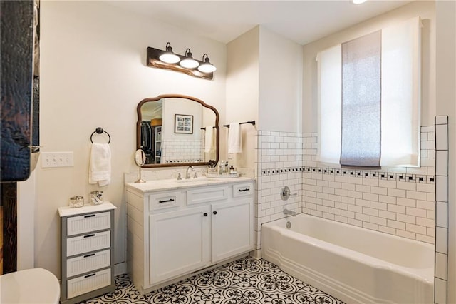 bathroom with toilet, a tub, tile patterned floors, and vanity