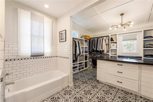 walk in closet with an inviting chandelier and light tile patterned floors