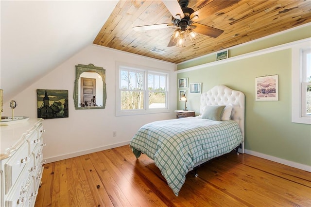 bedroom featuring light wood-type flooring, baseboards, visible vents, and vaulted ceiling