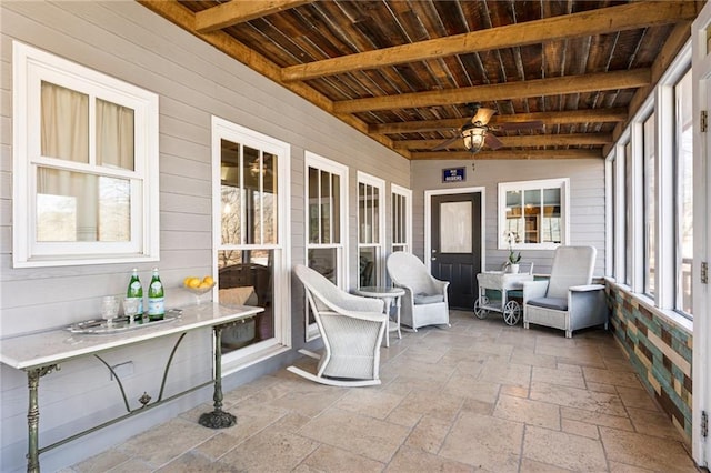 sunroom / solarium with beamed ceiling, wooden ceiling, and a ceiling fan