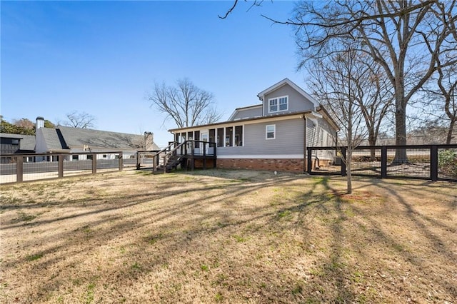 exterior space featuring a deck, a front lawn, and fence