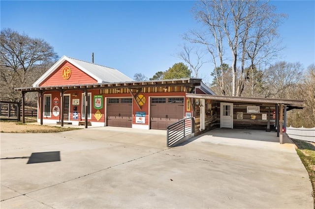 view of front of property with driveway, an attached garage, and fence