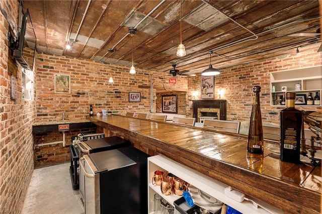 bar featuring ceiling fan, brick wall, concrete floors, wood ceiling, and pendant lighting