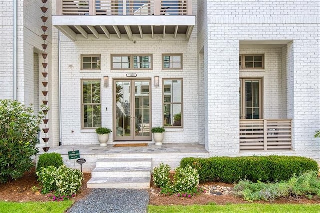 property entrance featuring a patio area, french doors, and a balcony