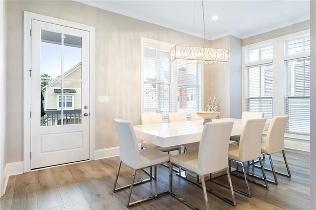 dining space with an inviting chandelier, baseboards, recessed lighting, and wood finished floors