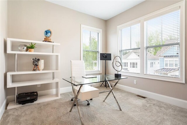carpeted office featuring visible vents and baseboards