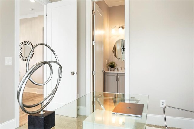 interior space with baseboards, ornamental molding, and a sink