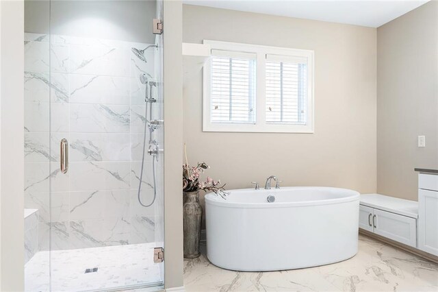 bathroom with marble finish floor, a marble finish shower, and a soaking tub