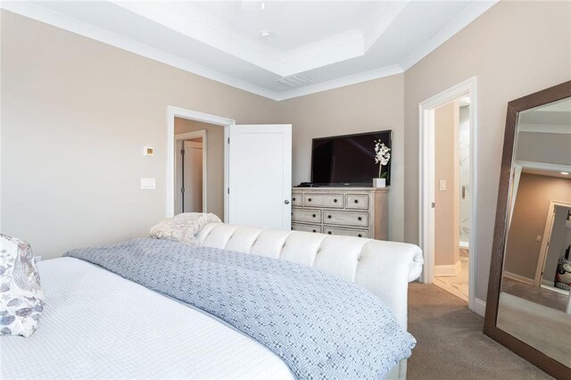 carpeted bedroom with ornamental molding and a raised ceiling