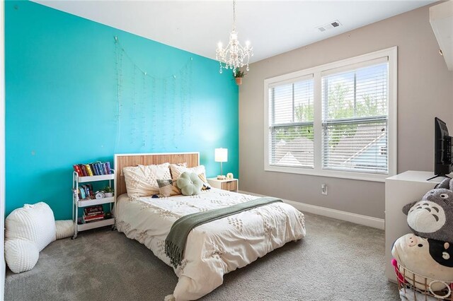 carpeted bedroom with baseboards, visible vents, and an inviting chandelier