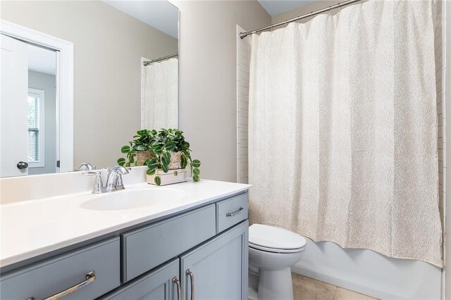 full bathroom with tile patterned floors, shower / bath combo, vanity, and toilet